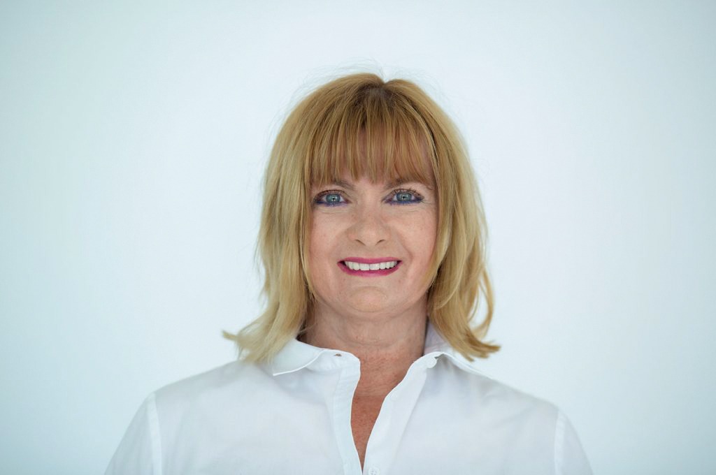 Angela Engelmann. Frau mit schulterlangen, blonden Haar, in einem weißem Hemd.