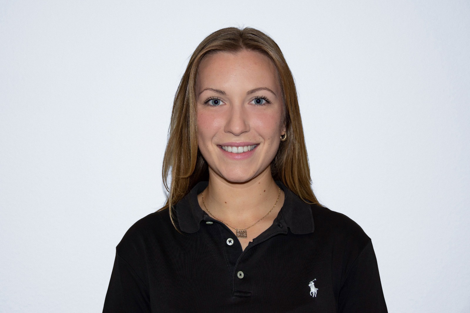 Anna Diebäcker. Frau mit langen, dunkel-blonden Haar, in einem schwarzen Polohemd.