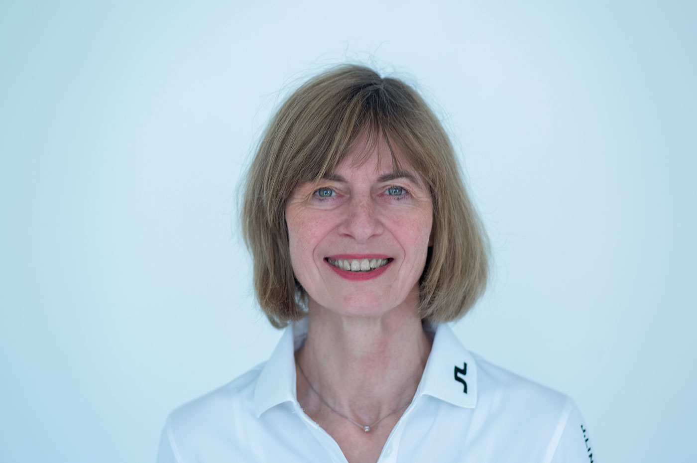 Hilke Hadenfeldt. Frau mit schulterlangen, blonden Haar, in einem weißem Hemd.