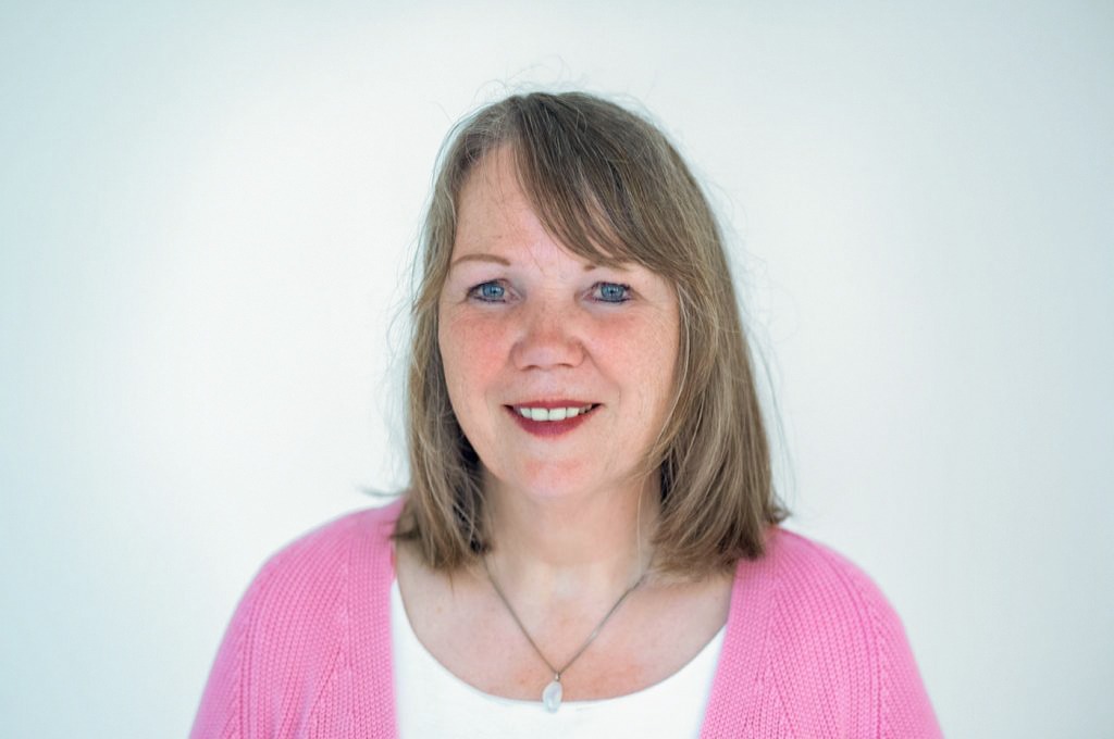 Ulrike Kecker. Frau mit schulterlangen, blonden Haar, in einem weißem Hemd und rosa Strickjacke.